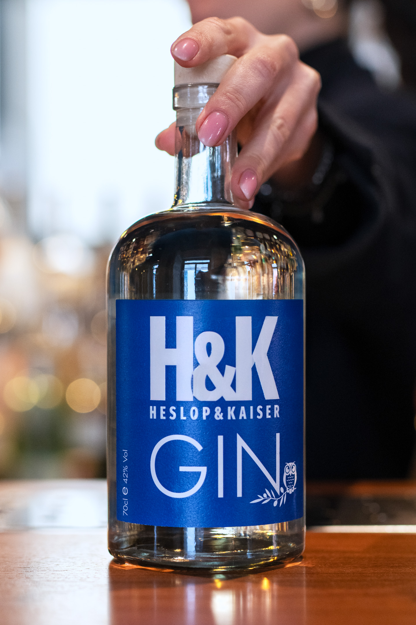 Heslop & Kaiser Gin bottiglia blu in mano barman dettaglio etichetta